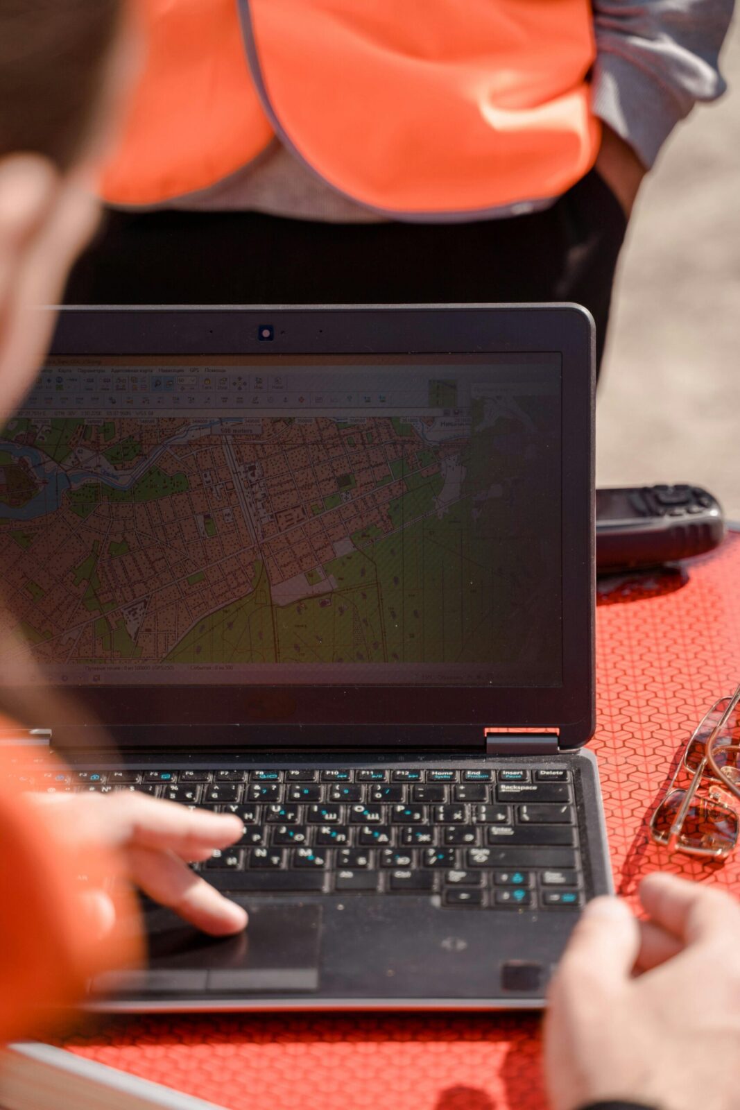 A field surveyor uses a laptop for mapping and navigation outdoors, ensuring accuracy. South Canterbury